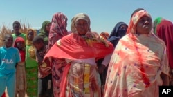 FILE - Sudanese refugees displaced by the conflict in Sudan gather to receive food staples from aid agencies at the Metche Camp in eastern Chad on March 5, 2024.