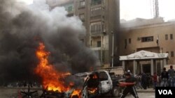 Demonstran Mesir membakar sebuah mobil di depan kantor polisi dekat piramida di Giza.