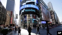 People walk past the Nasdaq MarketSite in New York, April 5, 2016.