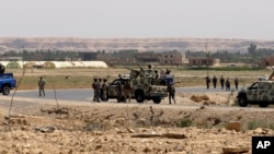 FILE - Iraqi soldiers patrol along the border between Syria and Iraq in Qaim, located in the Euphrates river valley 200 miles (320 kilometers) west of Baghdad, Iraq, July 20, 2012. 