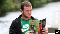 Pemain Manchester United Wayne Rooney berpose dengan bukunya "Wayne Rooney: My Story So Far", di Manchester, Inggris (10/8/2006). Karena cedera Rooney tidak turun bertanding melawan Klub Chelsea hari Minggu ini.
