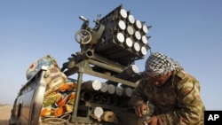 A rebel fighter scrubs his missiles at a front line checkpoint on the road between Bin Jawad and Nawfiliyah, Libya, March 29, 2011
