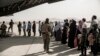 FILE - In this image provided by the U.S. Marine Corps, evacuees wait to board a Boeing C-17 Globemaster III during an evacuation at Hamid Karzai International Airport in Kabul, Afghanistan, Aug. 30. 2021.