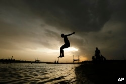 ARHIVA -Dečak skače u reku Gang u Indiji tokom vrelog sunačnog dana, 27. maja 2020. (Foto: AP/Rajesh Kumar Singh)