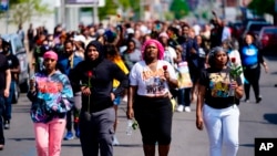 People march to the scene of a shooting at a supermarket in Buffalo, N.Y., May 15, 2022.