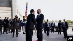 U.S. President Joe Biden, right, shakes hands with South Korean President Yoon Suk Yeol at the People's House, May 21, 2022, in Seoul. 