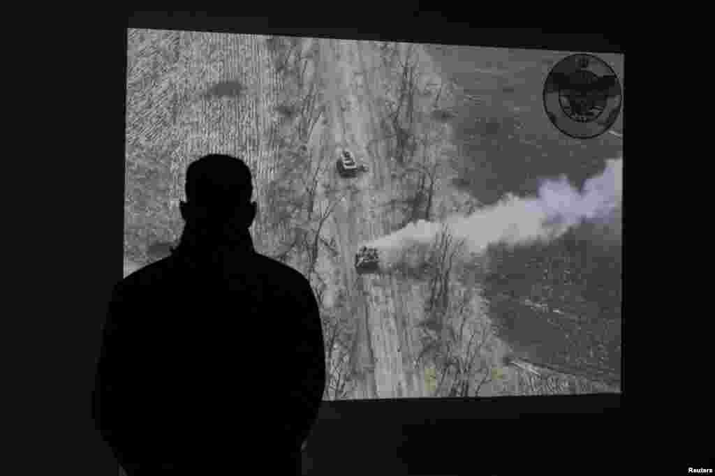 A man watches a drone video of an attack to a Russian tank at an exhibition of the ongoing Russian invasion of Ukraine, in the National Museum of the History of Ukraine in the Second World War, as Russia celebrates Victory Day marking the 77th anniversary of the victory over Nazi Germany in World War Two, in Kyiv, Ukraine.