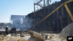 An Ukrainian firefighter works near a destroyed building on the outskirts of Odesa, Ukraine, May 10, 2022.