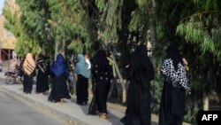 Burqa-clad women walk along a street in Kandahar, Afghanistan, on May 7, 2022.