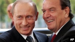 FILE - Then-German Chancellor Gerhard Schroeder, right, welcoming Russia's President Vladimir Putin in Berlin, Germany, Sept. 8, 2005. 