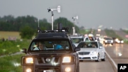 FILE - In this May 19, 2010 file photo taken near Kingfisher, Okla., storm chasers and spectator vehicles clog the road and shoulder of Highway 81.