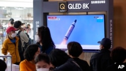 FILE - People watch a TV showing a file image of North Korea's missile launch during a news program at the Seoul Railway Station in Seoul, South Korea, May 7, 2022.