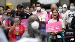 Chandler Jones, right, 26, from Baltimore County who will graduate this spring from the University of Baltimore School of Law, participates in a pro-choice rally in Baltimore, Saturday, May 14, 2022.