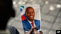 FILE - A person holds a photo of late Haitian President Jovenel Moise during his memorial ceremony at the National Pantheon Museum in Port-au-Prince, Haiti, July 20, 2021.