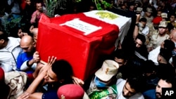 Men carry the coffin of soldier Ahmed Mohamed Ahmed Ali, who was killed in battle, during his funeral in Qalyubia province, Egypt, May 8, 2022. At least 11 Egyptian troops were killed May 7, 2022 in a militant attack on a water pumping station east of the