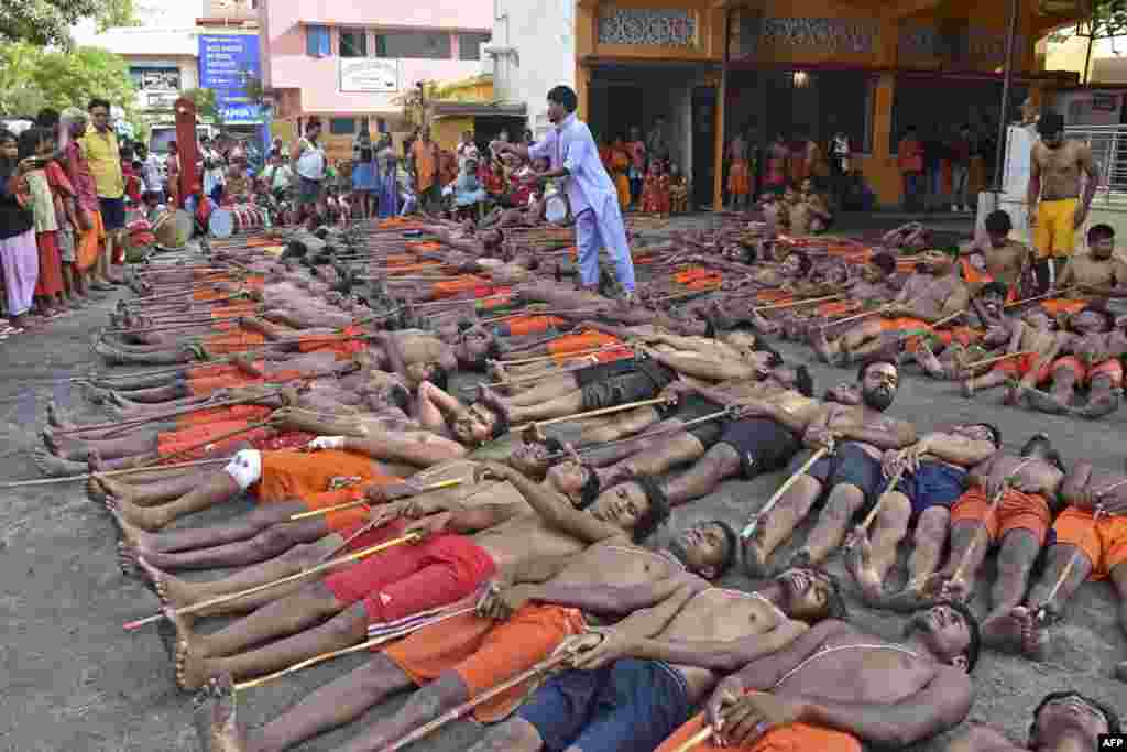 Tribal farmers perform a ritual as part of prayers for rain, prosperity and good health during the Manda Puja festival outside the Lord Shiva temple on the outskirts of Ranchi, India.