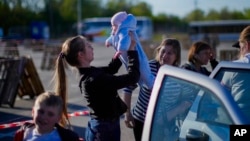 A family who fled from Enerhodar is reunited upon their arrival to a reception center for displaced people in Zaporizhzhia, Ukraine, May 6, 2022. 