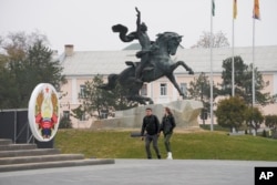 People walk past the equestrian statue of Russian Generalissimo Alexander Suvorov in Tiraspol, capital of Moldova's pro-Russian breakaway region of Transnistria, Nov. 1, 2021.