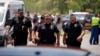 Police officers walk near Robb Elementary School following a mass shooting in Uvalde, Texas, May 24, 2022.