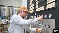 A worker pours a pint of beer at Pressure Drop Brewery, in north London, on May 21, 2022. 