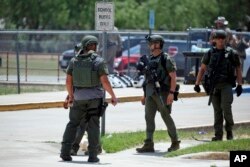 Law enforcement personnel stand outside Robb Elementary School following a shooting, Tuesday, May 24, 2022, in Uvalde, Texas. (AP Photo/Dario Lopez-Mills)