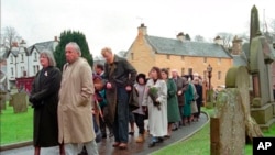 FILE - People file into Dunblane Cathedral in Dunblane, Scotland, for a service, March 17, 1996, in memory of the 17 people who were fatally shot at Dunblane Primary School. The 1996 incident was Britain's deadliest school shooting — and also the only one.