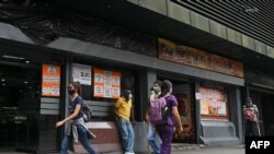 Con una economia nacional en crisis, muchos mecanismos ilícitos se mueven tras bastidores en Venezuela, de acuerdo a un informe de Transparencia Venezuela. Restaurante muestra carteles con precios de productos en dólares estadounidenses, en Caracas, el 22 de abril de 2022.