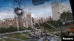 Burned cars are pictured through the glass of a damaged car in Saltivka neighborhood, amid Russia's attack on Ukraine, in Kharkiv, Ukraine, May 10, 2022.