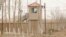 FILE - A security person watches from a guard tower around a detention facility in Yarkent County in northwestern China's Xinjiang Uyghur Autonomous Region on March 21, 2021.