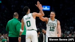 Jayson Tatum (0) et Grant Williams (12) des Boston Celtics célèbrent leur victoire contre les Bucks de Milwaukee, le dimanche 15 mai 2022. (AP Foto/Steven Senne)