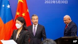 资料照片: 2022年5月30日中国外交部长王毅(中)在太平洋岛国外交部长会议上与斐济总理姆拜尼马拉马会面