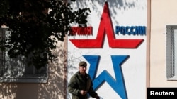 FILE - A Russian serviceman walks past the Operational Group of Russian Forces headquarters in Tiraspol, capital of Moldova's separatist region of Transnistria, Nov. 3, 2021. The banner reads "Army of Russia."