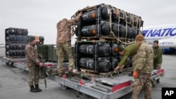 Ukrainian servicemen unload Javelin anti-tank missiles, delivered as part of U.S. security assistance to Ukraine, at Boryspil airport, outside Kyiv, Ukraine, Feb. 11, 2022.