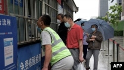 People queue to be tested for COVID-19 at a swab collection site in Beijing, May 29, 2022. 