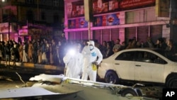 Officials and onlookers look at the remains of a drone aircraft that Houthi rebels claimed to have shot down in Sanaa, Yemen, on May 23, 2022. 