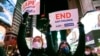People hold signs in support of Asian American Pacific Islander communities while attending a candlelight vigil in honor of Michelle Alyssa Go, a victim of a recent subway attack, at Times Square on Jan. 18, 2022, in New York.