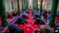 FILE - Uyghurs and other members of the faithful pray during services at the Id Kah Mosque in Kashgar in western China's Xinjiang Uyghur Autonomous Region, as seen during a government organized visit for foreign journalists on April 19, 2021.