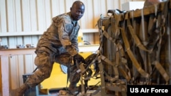 FILE - A US Air Force senior airman secures a pallet with munitions at Travis Air Force Base, California, April 28, 2022.