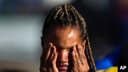 A person waits outside the scene as police investigate after a shooting at a supermarket on May 14, 2022, in Buffalo, NY.