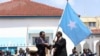 Outgoing Somalia President Mohamed Abdullahi Mohamed, left, also known as Farmaajo, presents the Somali flag to newly elected President Hassan Sheikh Mohamud on May 23, 2022. 