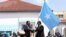 Outgoing Somalia President Mohamed Abdullahi Mohamed, left, also known as Farmaajo, presents the Somali flag to newly elected President Hassan Sheikh Mohamud on May 23, 2022. 
