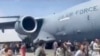 People run alongside a U.S. Air Force C-17 transport plane as it taxis down an airport runway in Kabul, Afghanistan, Aug. 16. 2021. Some were so desperate to escape the Taliban capture of their country that they held onto a jet as it took off and plunged to death. (AP Photo)