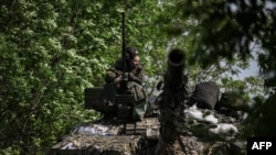 A Ukrainian serviceman keeps watch aboad a tank at a front line position near the city of Lysychans'k, eastern Ukraine, on May 20, 2022.
