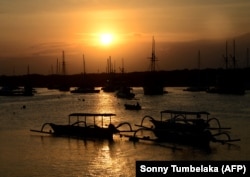 Kapal wisata yang digunakan para wisatawan ditambatkan saat matahari terbenam di sebuah dermaga di Pulau Serangan, Bali pada 6 Agustus 2021. (Foto: AFP/Sonny Tumbelaka)KA)
