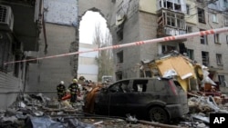 Ukrainian Emergency Service rescuers work at the scene of a building damaged by night shelling in Mykolaiv, Ukraine, Nov. 11, 2022.