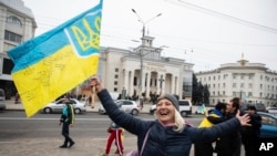 FILE - Ukrainians gather in downtown to celebrate the recapturing of their city Kherson, Ukraine, Saturday, Nov. 12, 2022. (AP Photo/Yevhenii Zavhorodnii)