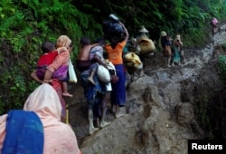 FILE - Rohingya refugees climb up a hill after crossing the Bangladesh-Myanmar border in Cox's Bazar, Bangladesh, Sept. 8, 2017.