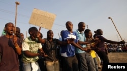 Striking platinum miners are seen gathered at Lonmin's Marikana mine in South Africa August 29, 2012.