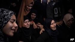 FILE-Palestinian women weep during the funeral of Mohammed al-Shaer, one of eight Palestinians who drowned off the coast of Tunisia, in Rafah, southern Gaza Strip, Dec. 18, 2022.