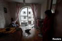 La residente local Kateryna se encuentra dentro de una habitación de su apartamento dañado por un ataque con drones rusos, en medio del ataque de Rusia a Ucrania, en Kiev, Ucrania, el 30 de diciembre de 2022. REUTERS/Valentyn Ogirenko.